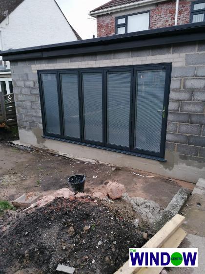 Anthracite Grey Aluminium Bi-folding Door with Integral Venetian Blinds
